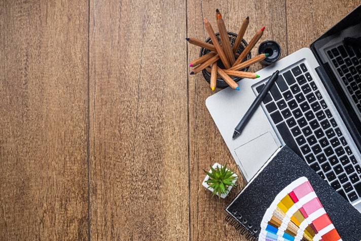 Creatieve werkplek met laptop, kleurstalen en ontwerpmaterialen
